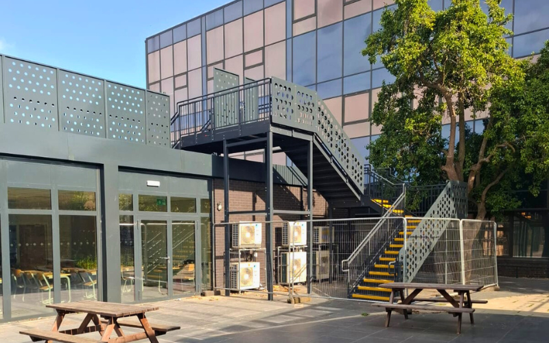 A building with a staircase and a tree